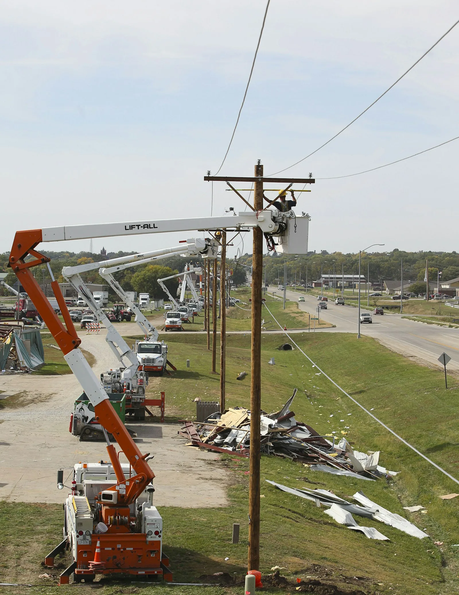 A field technician working from a bucket crane truck beside a utility pole