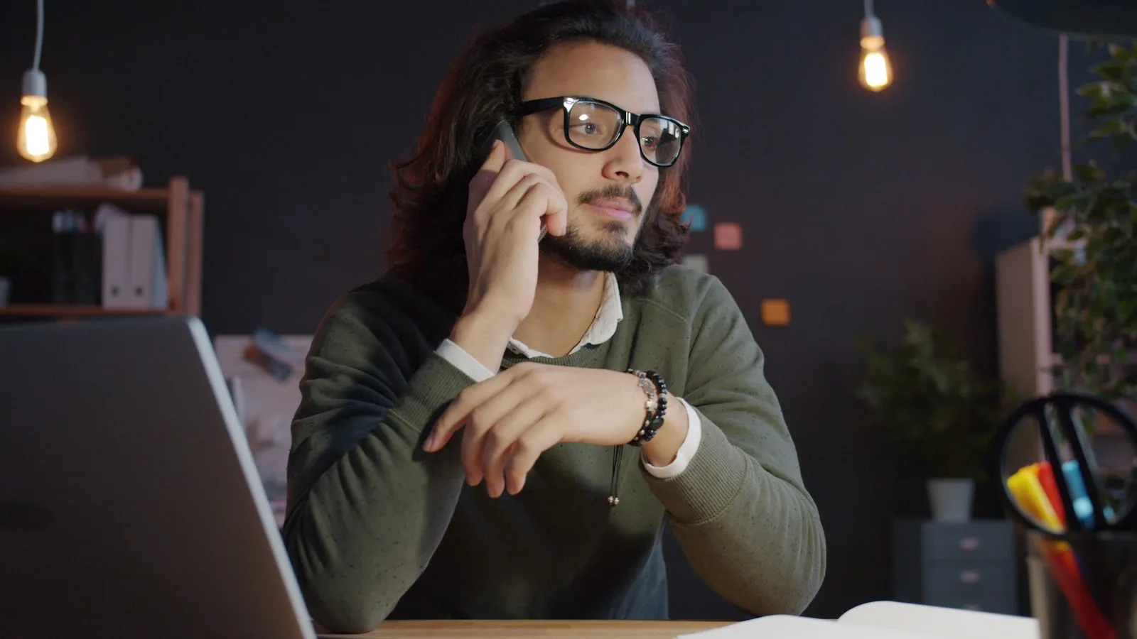 A man talking on the phone at a desk