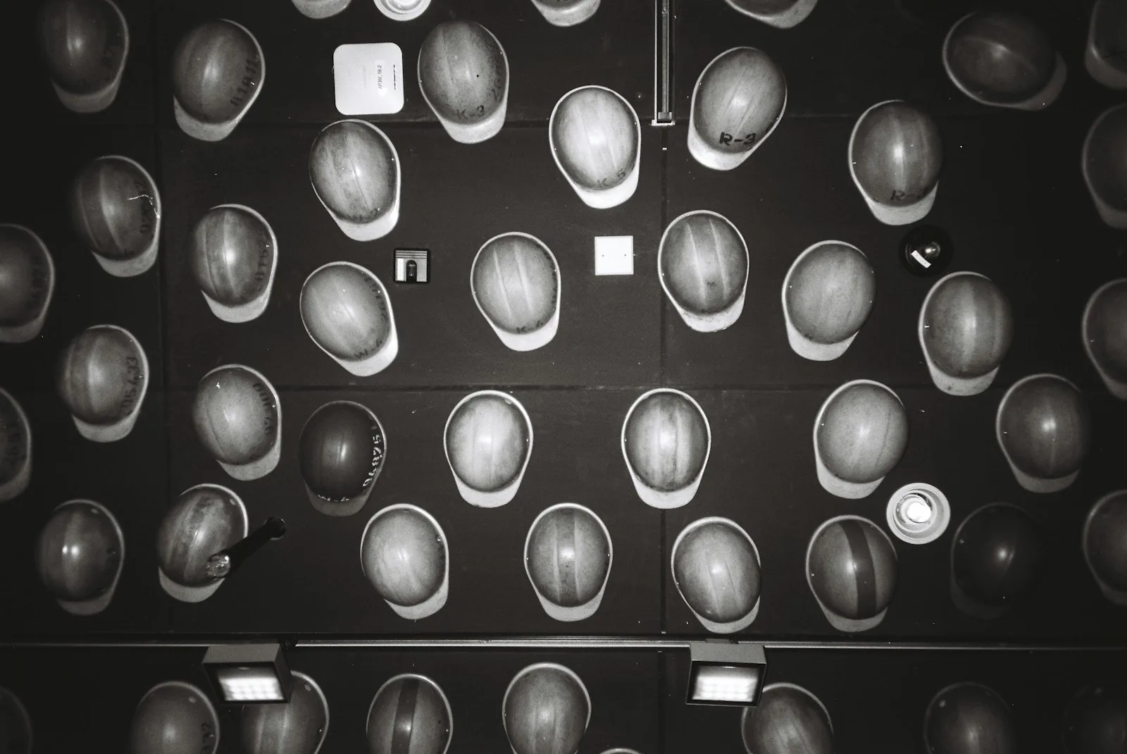 Rows of hard hats arranged on a wall